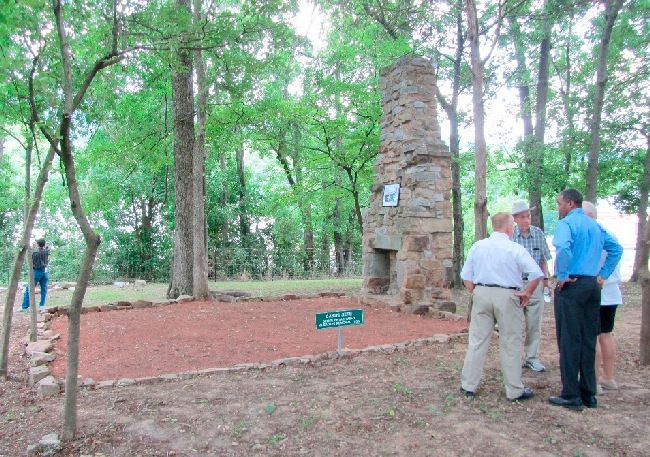 Attendees gather next to the Cabin’s chimney.